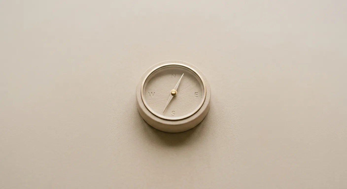 Abstract sandstone compass resting on a minimal warm beige surface representing generative engine optimization direction